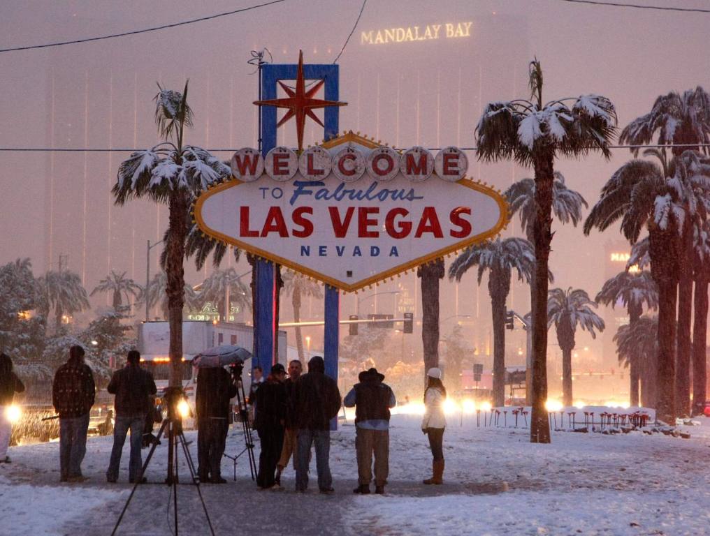 People ad TV crews in front of the Las Vegas sign when it snowed