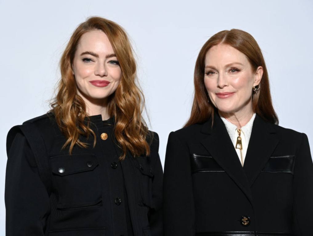 Two redhead women stand next to each other in black coats. They are both famous redheads in Hollywood.