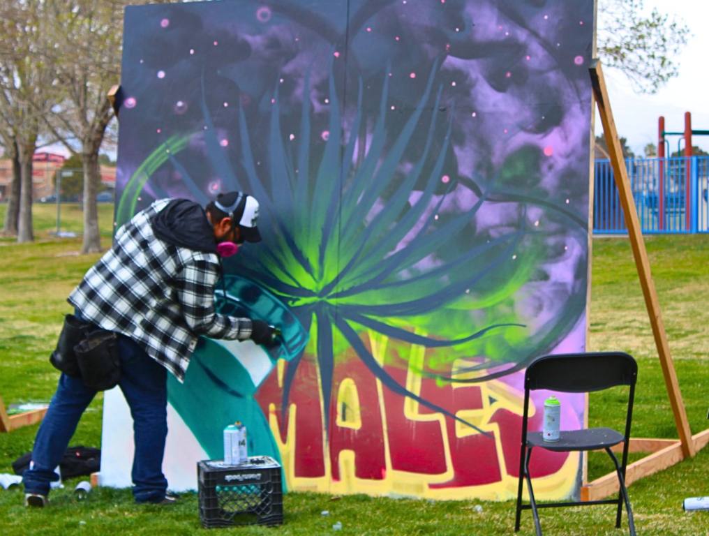 A spray painter painting a mural