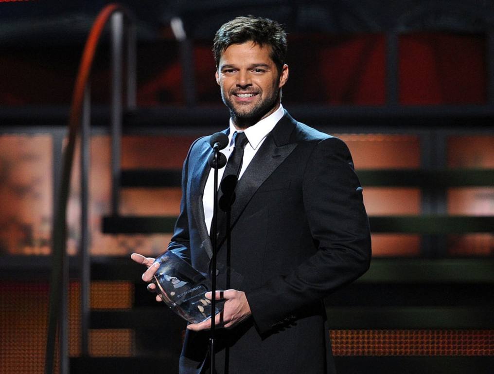 Ricky Martin in black suit, accepts award