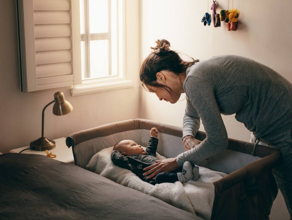 A mother making sure that her baby is going to sleep