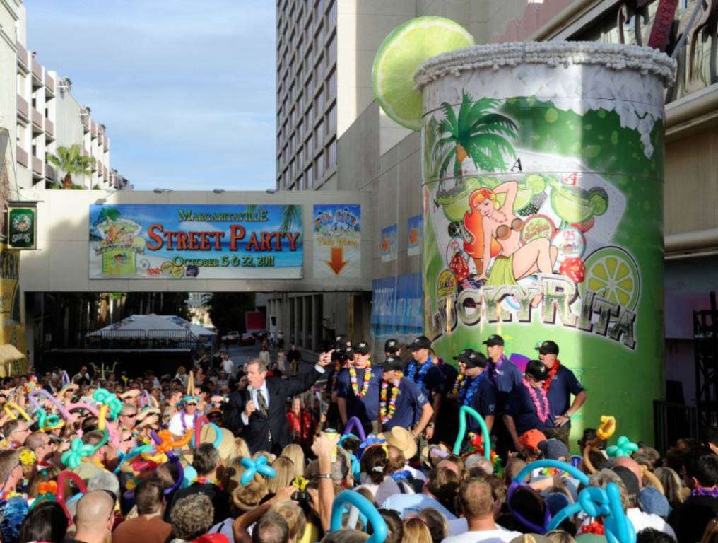 A crowd of people gather on the street in front of the Flamingo Casino in Las Vegas. They are standing around a giant margarita and celebrating.