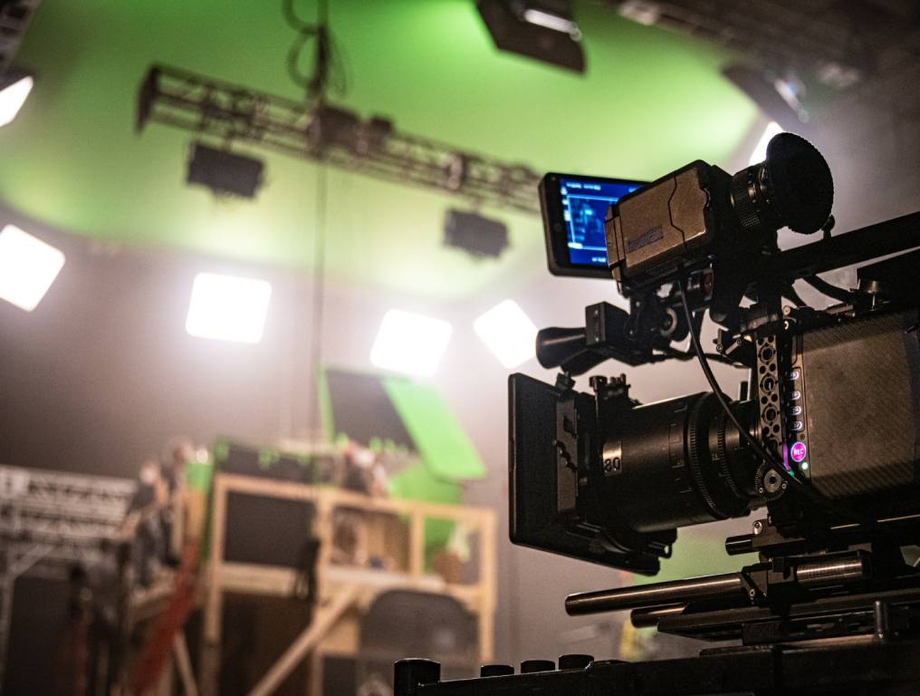 Movie studio with green screen walls and a film camera, set to film in an indoor studio. What Summerlin studios may look like.