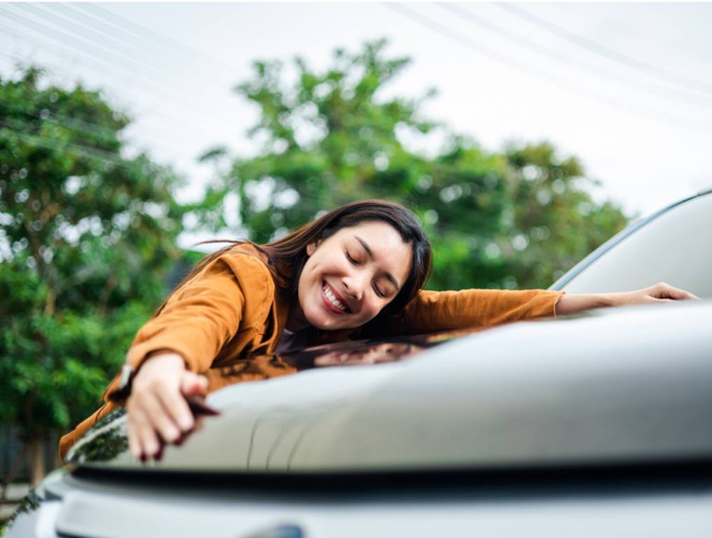 Young beautiful asian woman getting the new car. She hugged her car and was very happy.