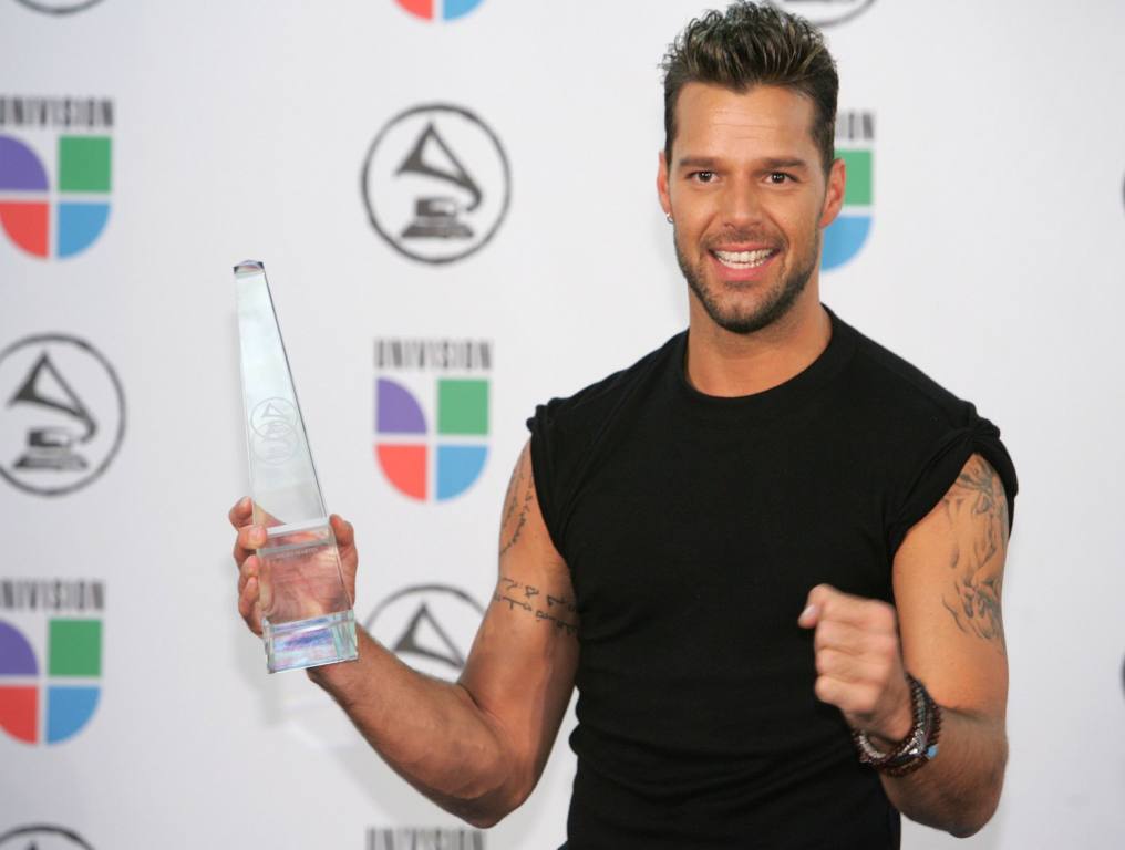 Ricky Martin holding award with bare arms showing