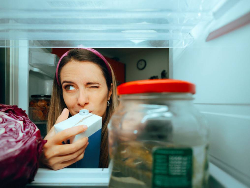 Cautious millennial girl checking the smell of her diary product