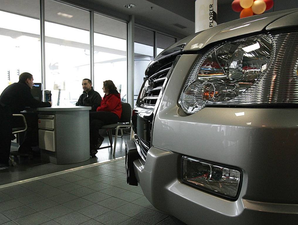 In a recent survey, our state's respondents named Ford as Nevada's dream car. Photo of a Ford car dealer showroom. The front of a brand new, silver Ford vehicle is seen in the foreground on the showroom floor. Behind that, a male/female couple is sitting at a desk talking to a male car salesperson. Above the front grill of the new Ford vehicle are some colorful balloons. There is sunlight streaming through the showroom windows behind the salesperson and the couple trying to purchase a vehicle.