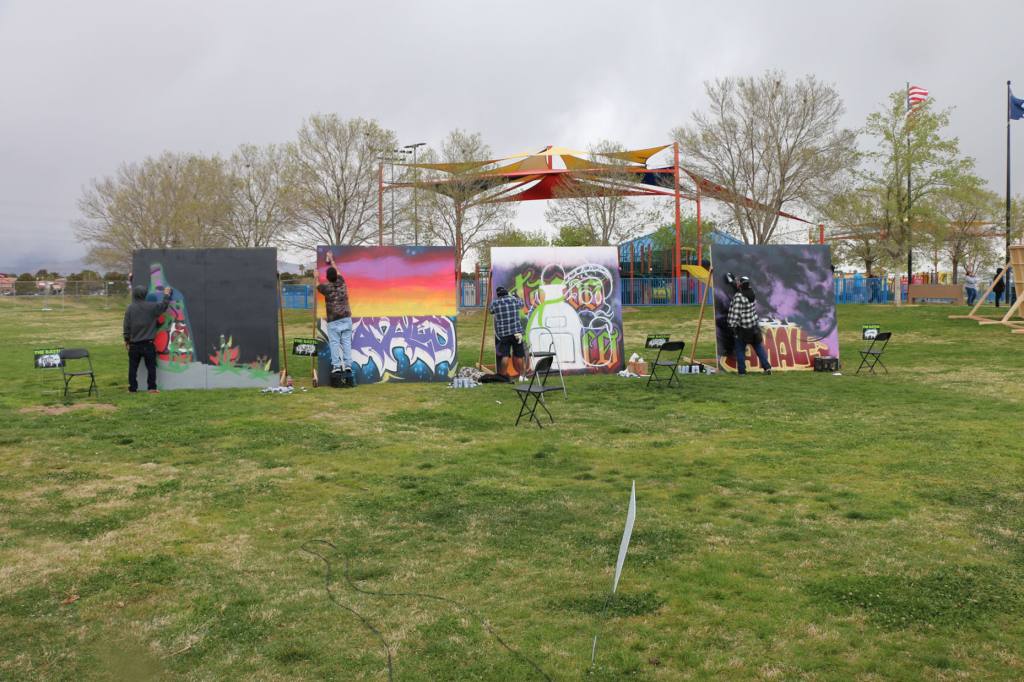 The photo shows an "Art Battle" of four spray paint artists.