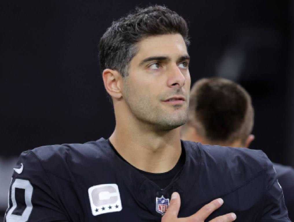 jimmy garoppolo in black jersey with hand over heart