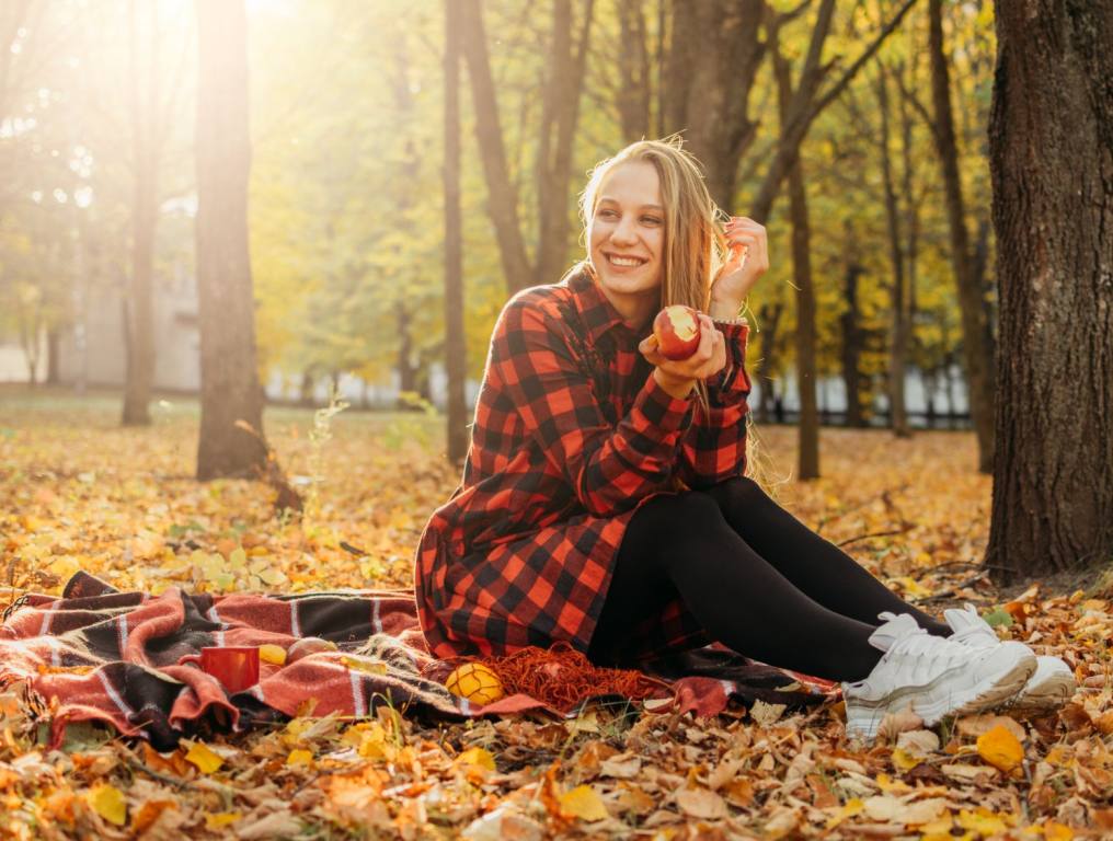 Woman sitting in a fall forest.