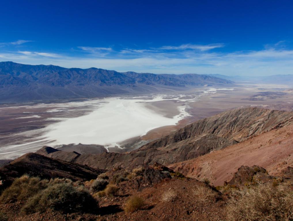 A mountain range in the foreground on the right, in front of a flat canyon below. The skies in the background are clear and blue. This is one of the most famous movie sets in the country.