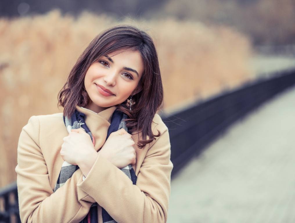 A woman hugging herself to feel happier.