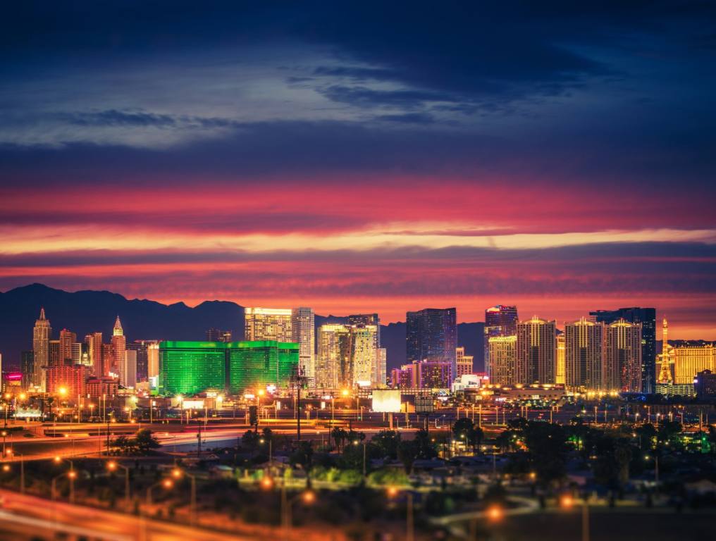 The Las Vegas Skyline at Scenic Dusk. The sky is purple and pink and the casinos are colorful and bright. Most scenic road in America concept.