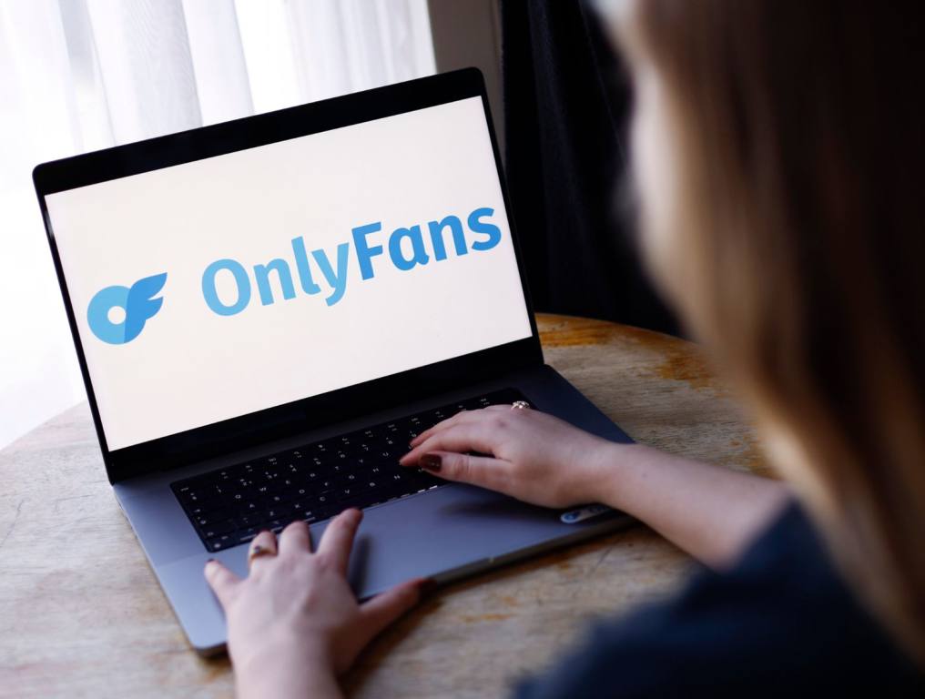 The OnlyFans Logo is displayed on a laptop