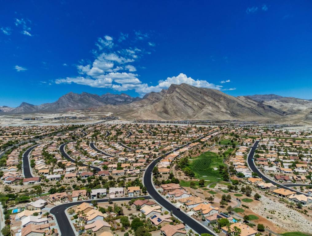 You need a six-figure salary to buy a house in Nevada. An aerial photo of the Summerlin area, with rows of houses in different subdivisions. It is a sunny day with blue skies. The aerial shot also takes in the Spring Mountains to the west of Summerlin in the background.