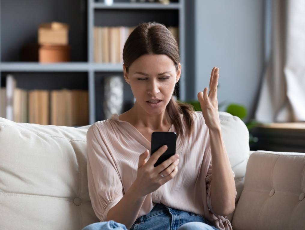 A young woman allowing her phone to make her life miserable.