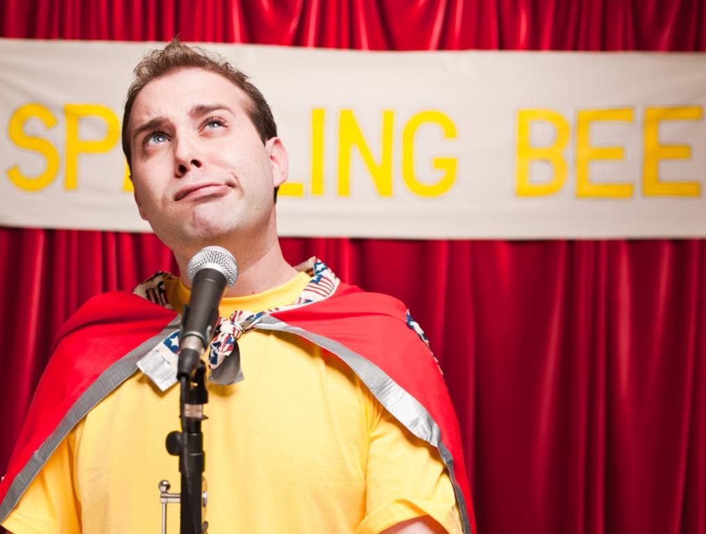 A guy pretending to be a kid at a spelling bee.