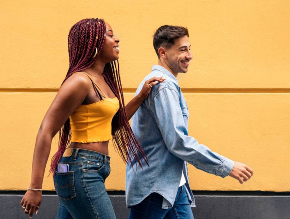 Cute young couple wearing casual clothes having fun in the streets of Madrid and walking.