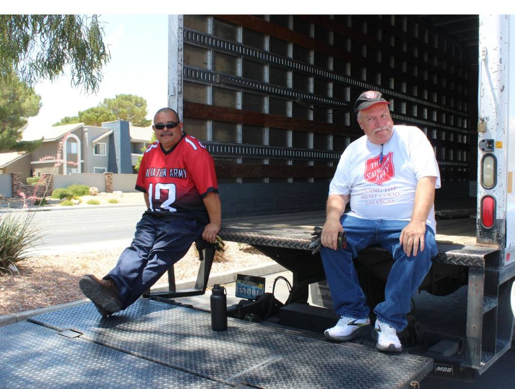 Two men sitting on the truck bed