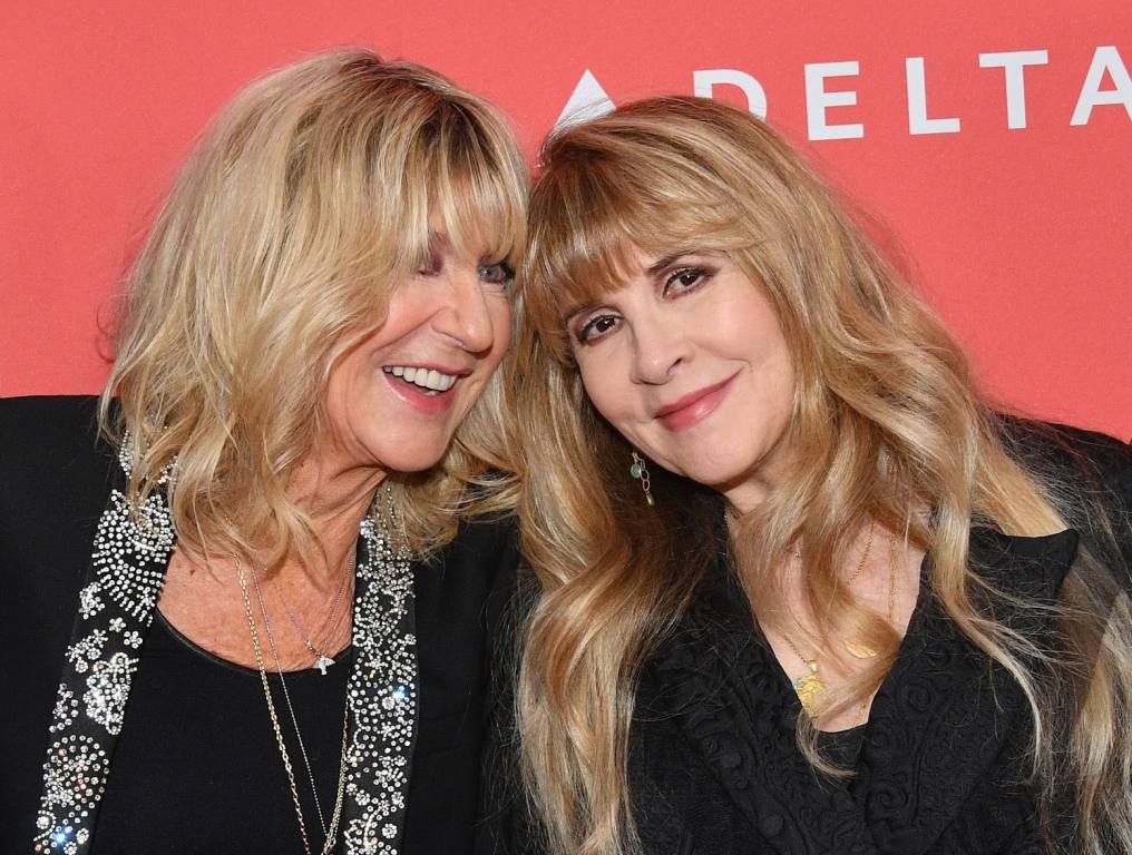 Christine McVie and Stevie Nicks posing for a photo on the red carpet.