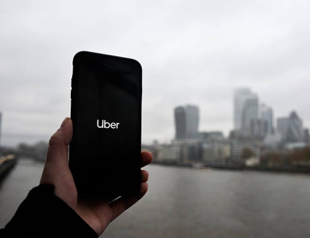 In this photo illustration the Uber logo is displayed on a phone in front of the City of London on November 25, 2019 in London, England.