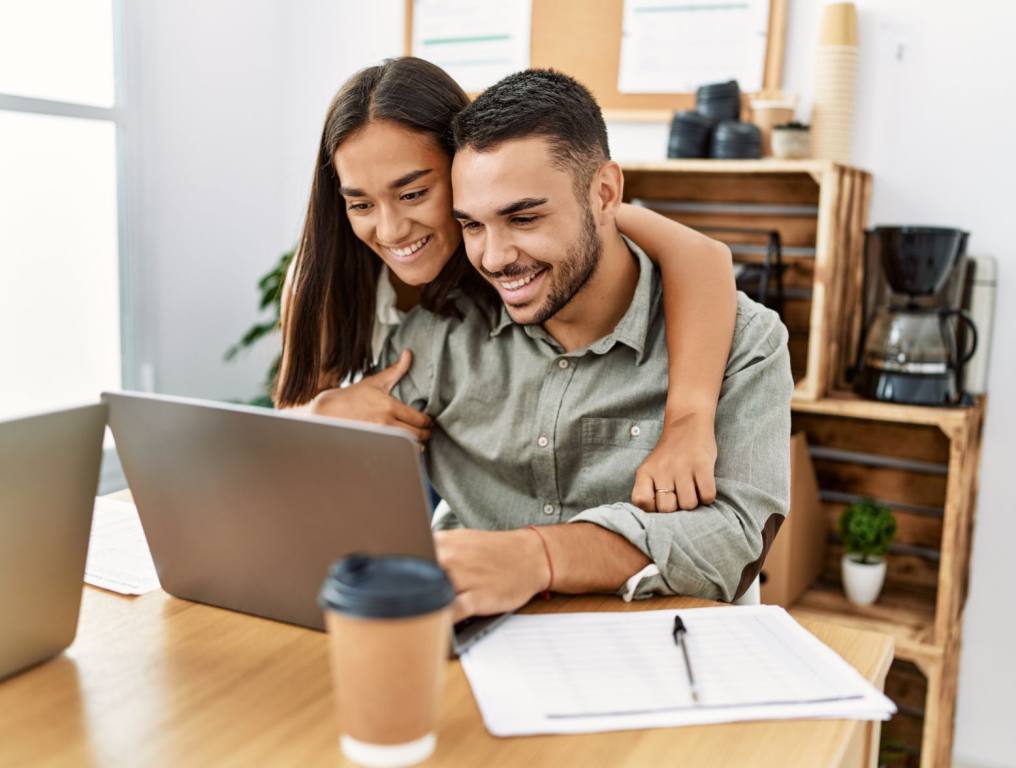 A happy couple on the computer.