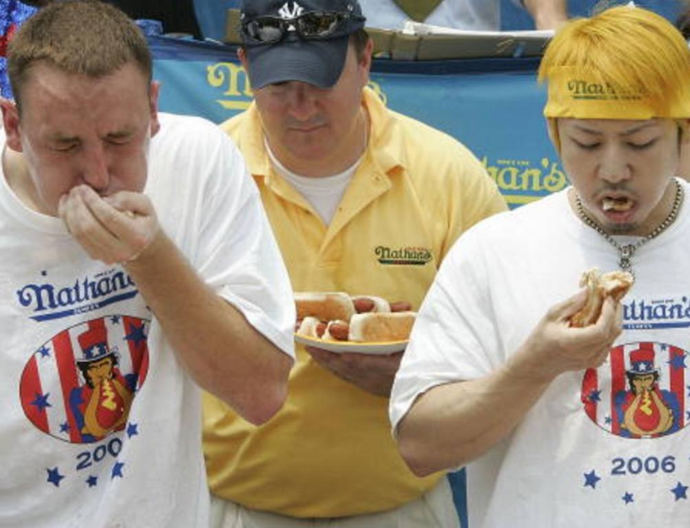 Takeru "The Tsunami" Kobayashi of Japan, (R) and challenger Joey Chestnut of San Jose, California (L) down hot dogs at the annual Nathan's hot dog eating contest July 4, 2006