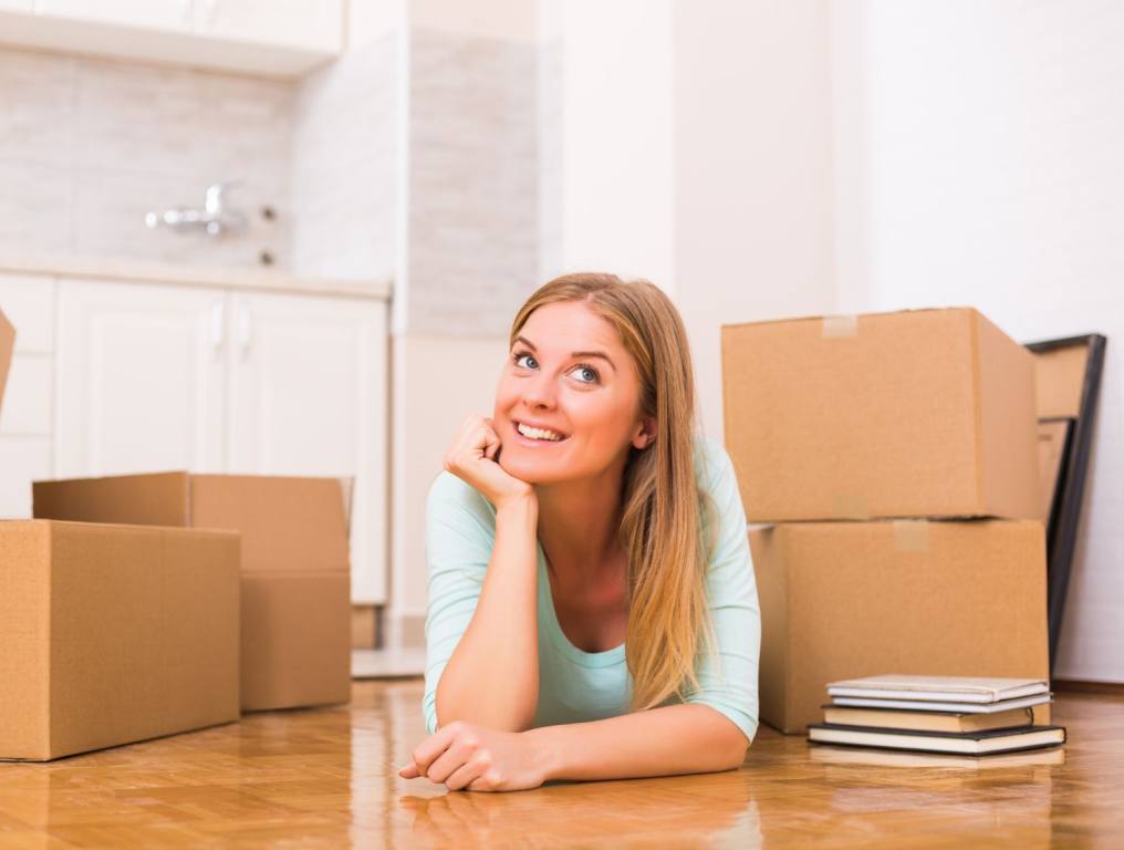 Woman in her new apartment. You're going to want to follow some tips to get approved quickly for an apartment, mortgage or loan.