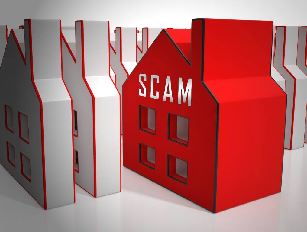 Real estate fraud is becoming a huge problem. 3-D image depicts property sale scam with house icons set up in rows. All the houses are white with red outlines, except for the house in the center of the image. It is bright red with white capital letters reading "SCAM."