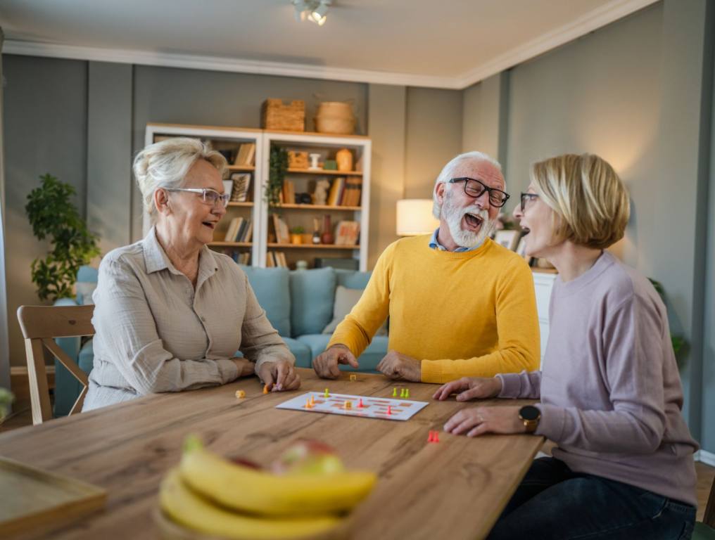 Elderly people at a table laughing.