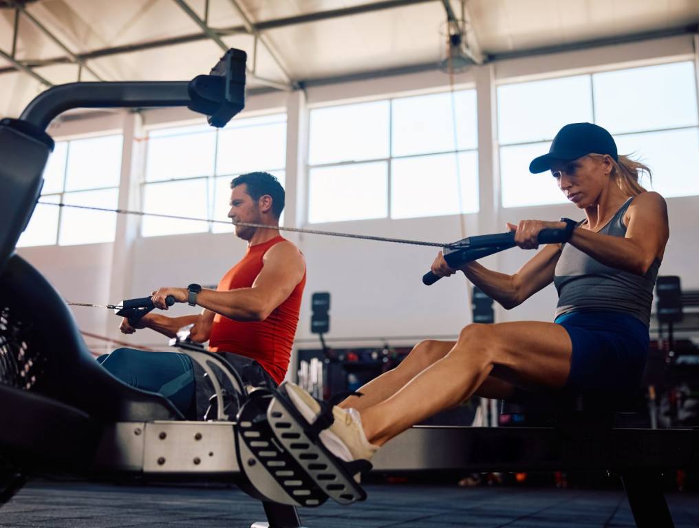 A man and a woman on a rowing machine in a CrossFit Gym. This article is about the three best CrossFit gyms in Las Vegas.