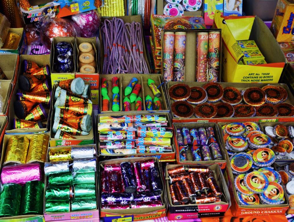 Photo of illegal July 4th fireworks for sale at a roadside stand. There are a variety of boxes filled with all sort of colorful packages of fireworks.