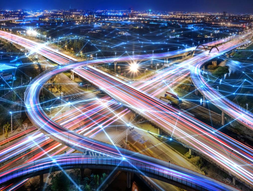 Las Vegas rush hour one of the top 5 deadliest rush hours in the U.S. Time lapse photo taken during evening rush hour in a big city. Overhead view of a free way interchange shows vehicle headlights and taillights as long streams of white, blue, red, and violet streams of light. The city lights of building can be seen in the background as the sun sets on the horizon.