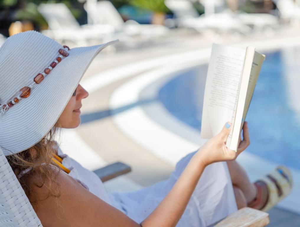 A woman reading a book outside. The experts at Reader's Digest have put together a tally of the best books of all time, including the very best book of all time.