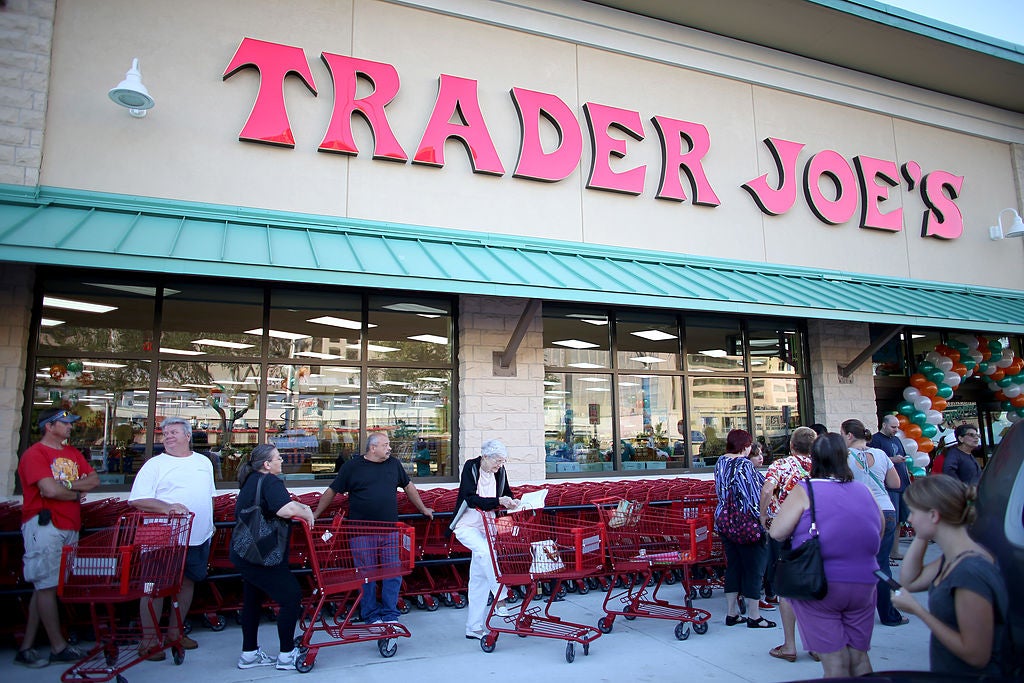 People lined up to enter a Trader Joe's grocery store on sunny day. Trader Joe's desserts