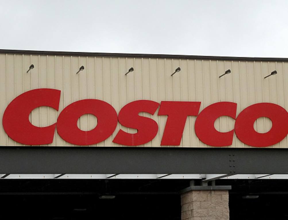 A Costco sign hangs over the entrance to a wholesale store