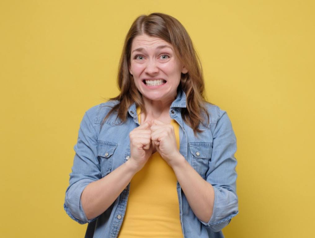 Awkward caucasian woman feeling embarrassed, confused nervous before exam isolated on yellow studio background. Omg I made a terrible mistake.