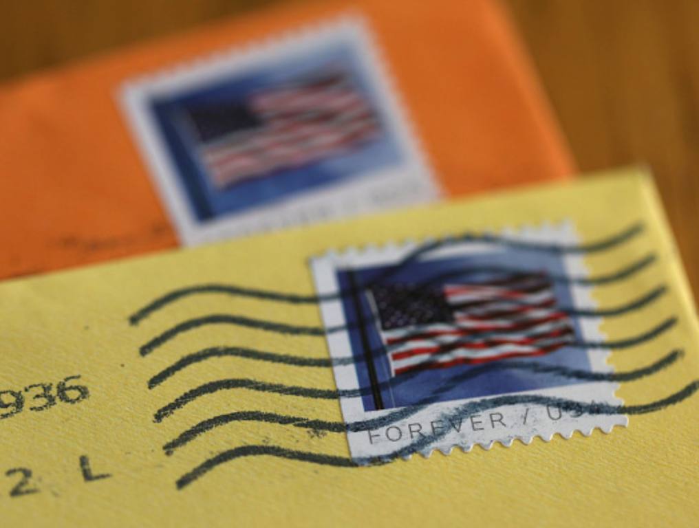 In this photo illustration, U.S. Postal Service (USPS) forever stamps are seen on envelopes