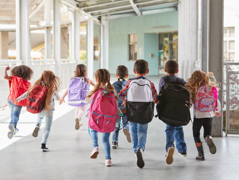 Kids walking into school together.