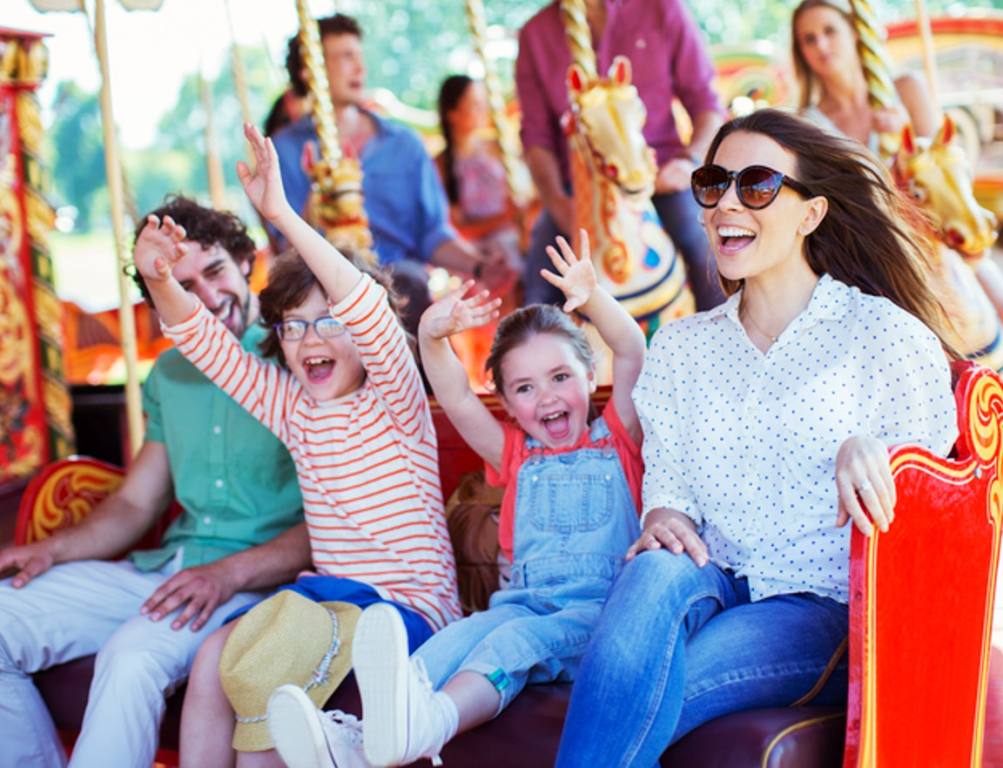 Family on carousel in amusement park