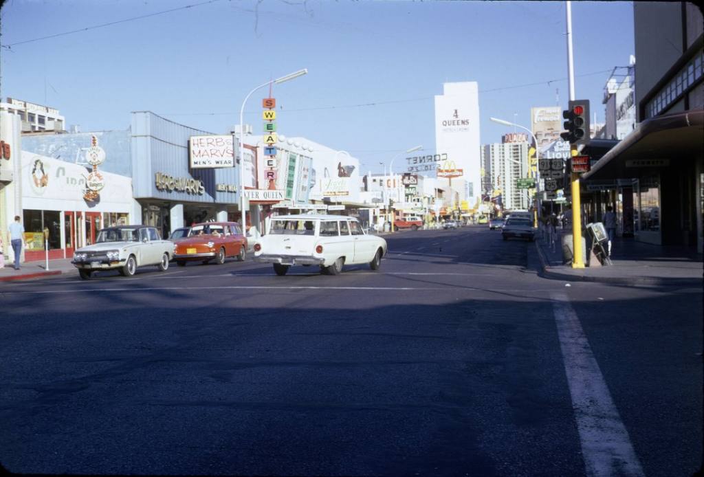 Fremont Street in Las Vegas, circa 1972, shows cars driving down the street, which is flanked by hotel casinos.