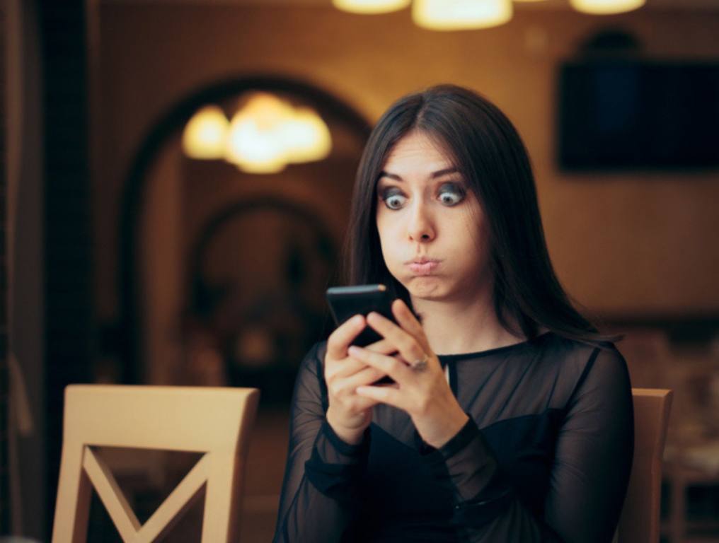 Surprised Young Woman Receiving a Text Message