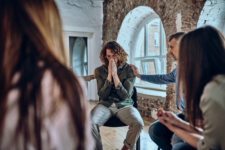 Honest conversation in group therapy. Diverse people comforting upset patients helping them deal with grief and other problems. Alcohol addict hides face ashamed of what he has done with his life. Selective focus