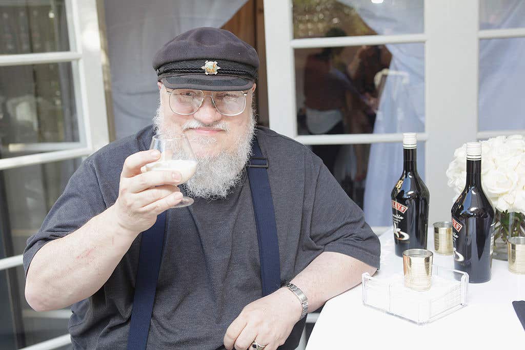 George R.R. Martin toasting with a drink