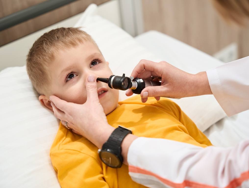 Doctor examining a kids nose for a Lego.