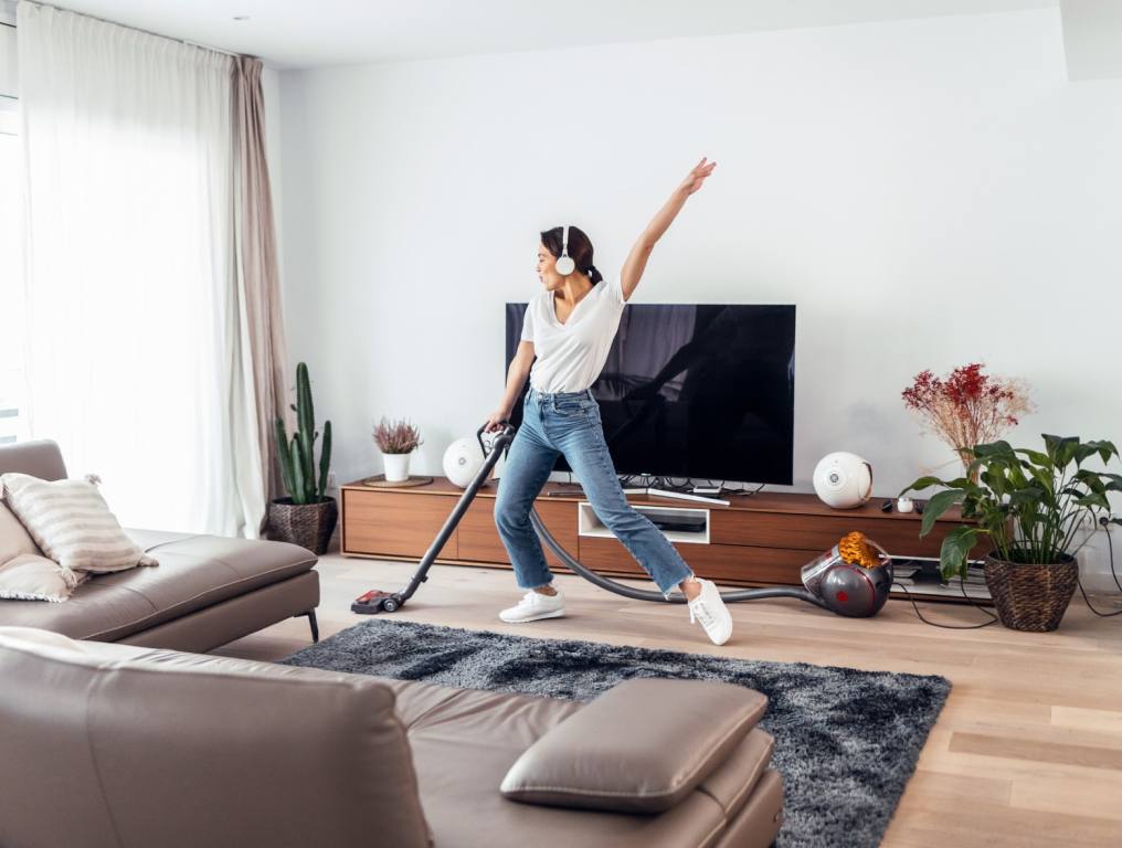 A woman living alone and vacuuming her apartment.