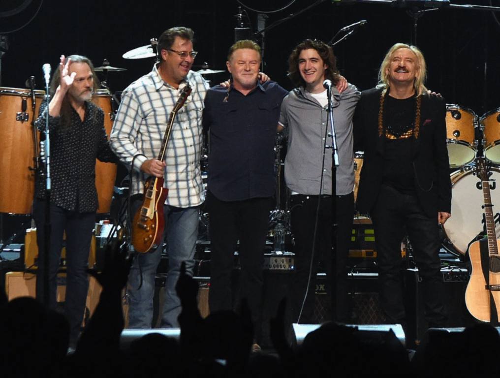 The Eagles band members are lined up on stage taking their bow after a concert. Concept: Eagles at the Sphere