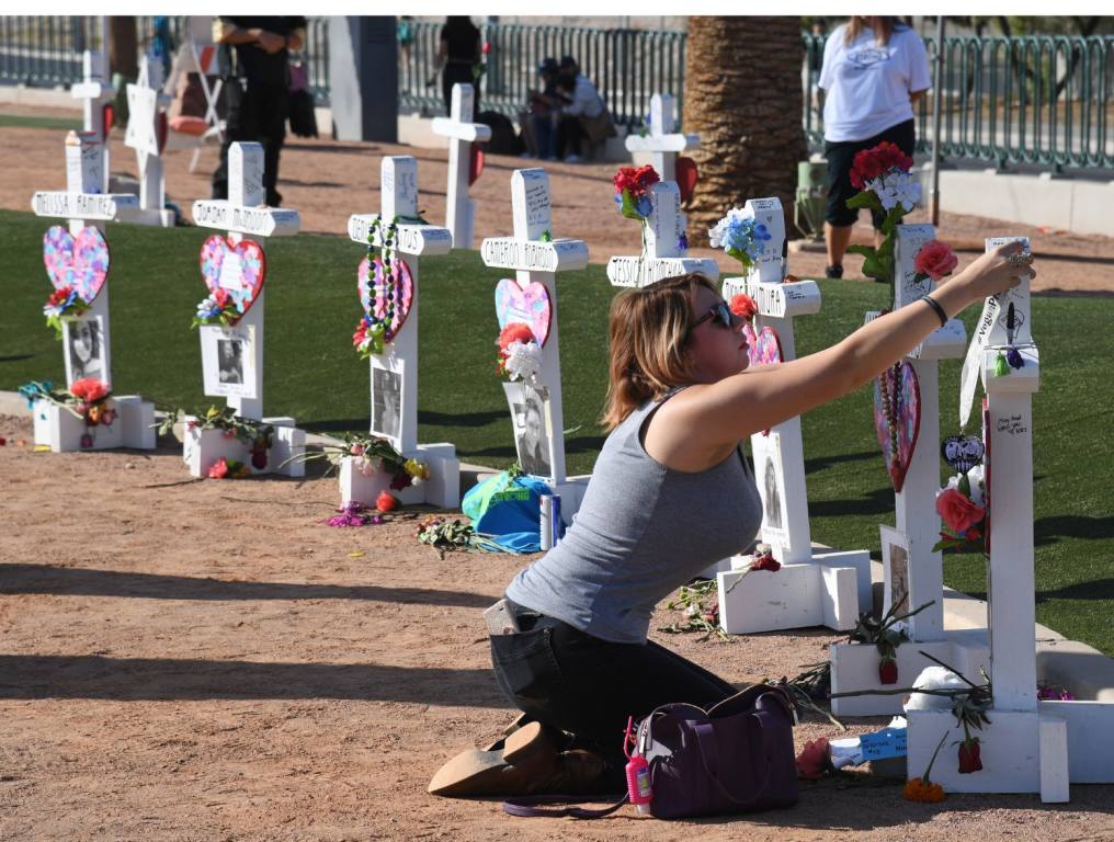 Ashley Schuck of Nevada places a medal she got for running for shooting victim Neysa Tonks in Saturday's Vegas Strong 5K on a cross set up for Tonks on October 1, 2018 in Las Vegas, Nevada. Retired carpenter Greg Zanis, who installed 58 crosses last year - one for each of the victims of the shooting - set up the memorial again with new crosses for the anniversary of the massacre. On October 1, 2017, Stephen Paddock opened fire on the Route 91 Harvest country music festival in Las Vegas killing 58 people and injuring more than 800 in the deadliest mass shooting event in U.S. history.