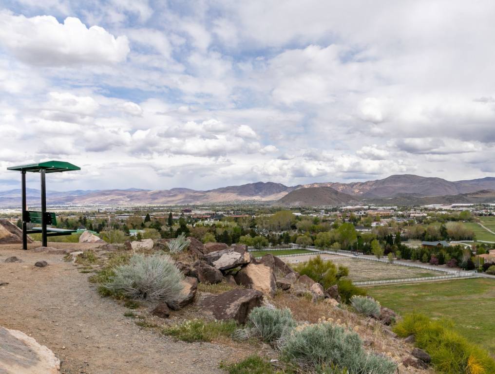 This is a photo of Reno in Nevada. It is a little cliff overlooking Reno with a bench.