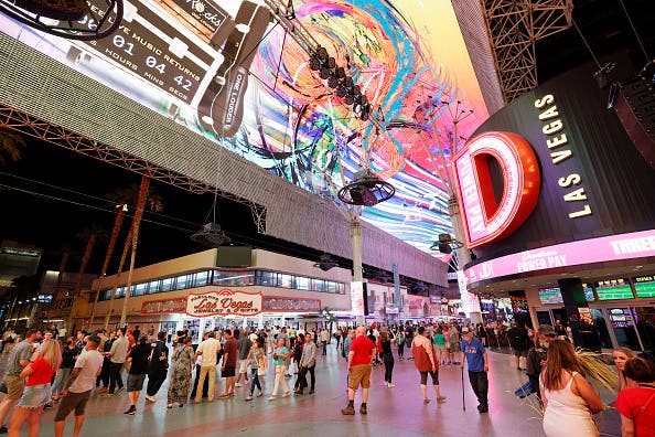 Visitors walk by the D Las Vegas and a gift store under the Viva Vision canopy attraction at the Fremont Street Experience on May 31, 2021 in Las Vegas, Nevada. Clark County is dropping all pandemic mandates as its COVID-19 mitigation plan expires at midnight on June 1, meaning businesses may operate at 100 percent capacity with no physical distancing restrictions. (Photo by Ethan Miller/Getty Images)